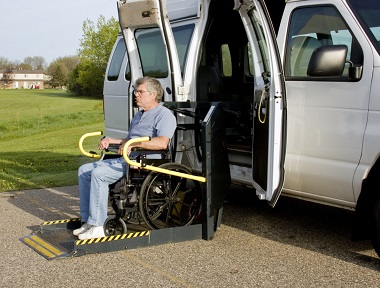 Gentleman using a wheelchair lift attached to a van